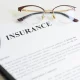 Magnifying glass,eyeglasses and insurance letter