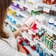 Woman choosing vitamins in pharmacy aisle