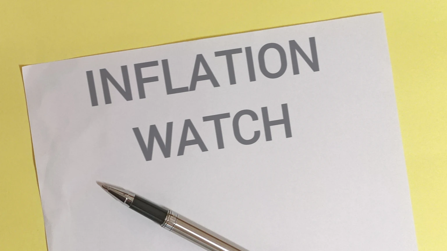 Inflation watch concept with pen on paper