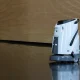 robotic cleaner or Modern floor cleaner glides across polished surface. Smooth motion reflects in glossy, dark floor. Warm wood paneling lines the background. Clean, quiet scene suggests efficiency and order.