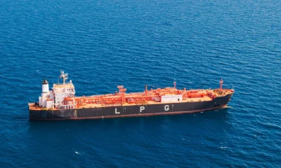 Vista aérea cercana de un buque petrolero de GLP transportando gas licuado de petróleo a través del profundo mar Mediterráneo, azul profundo.