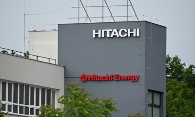 Hitachi and Hitachi Energy Logos on Factory Facade in Industrial Manufacturing Site