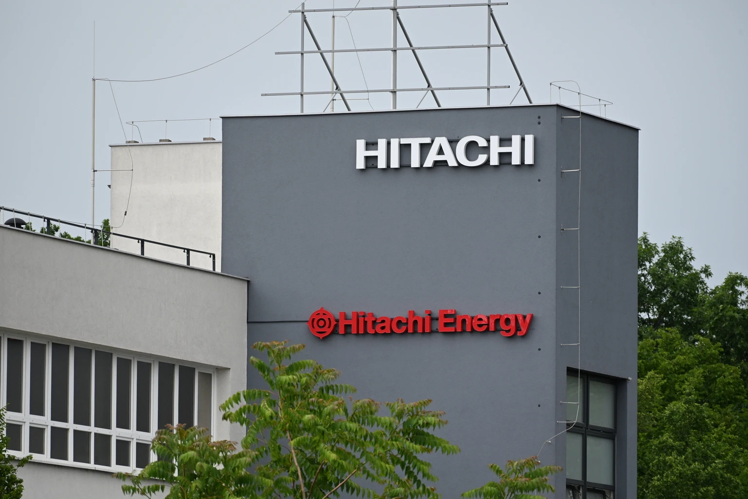 Hitachi and Hitachi Energy Logos on Factory Facade in Industrial Manufacturing Site