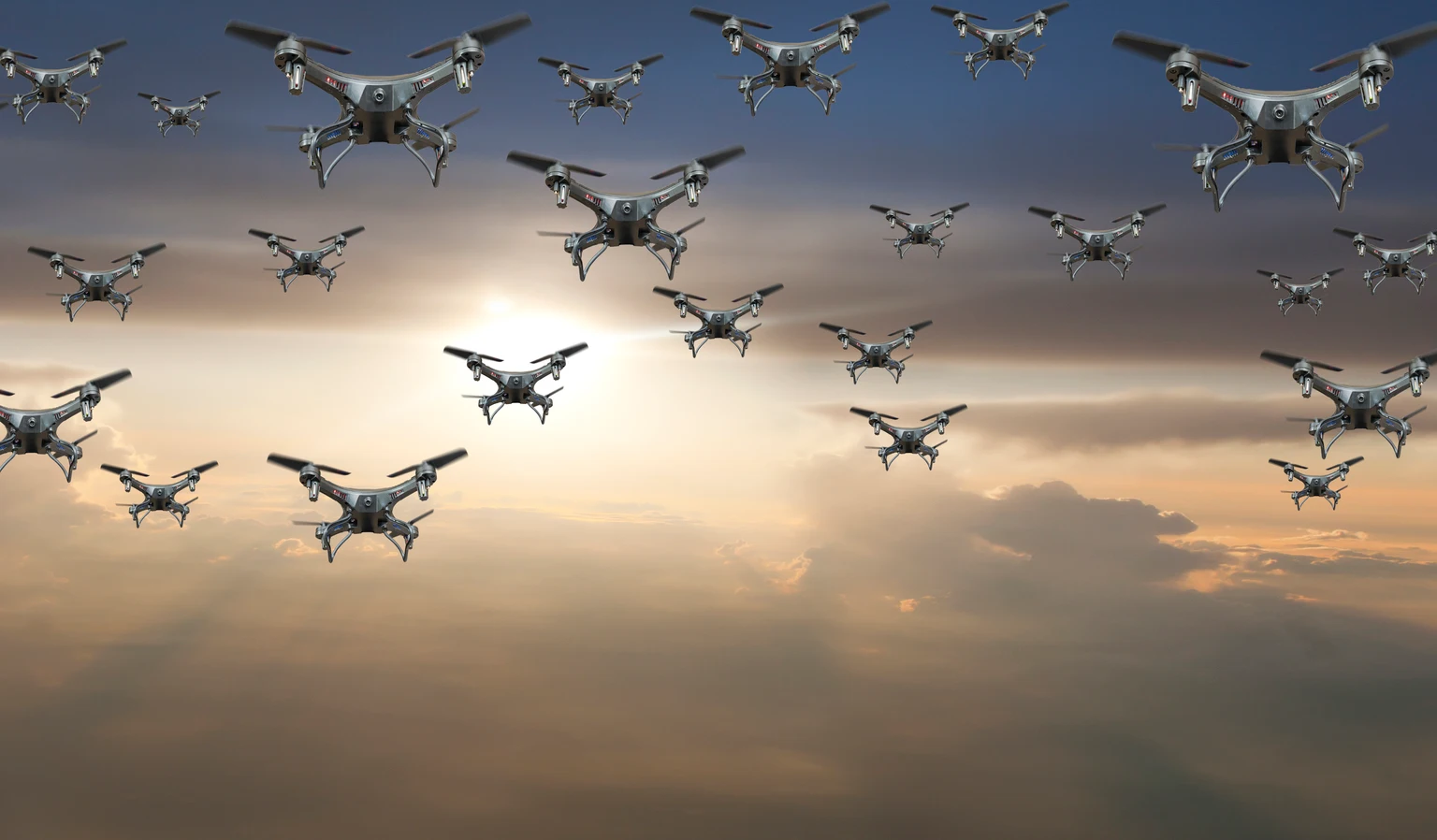 Flock of drones in the sky at sunset