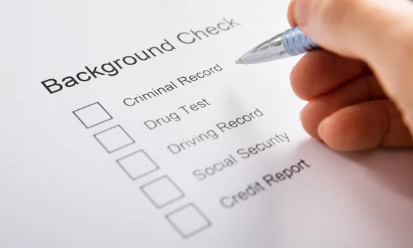 Person Hand Filling Background Check Form