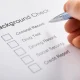 Person Hand Filling Background Check Form