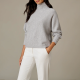 woman wears white pants and gray cashmere turtleneck