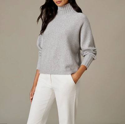 woman wears white pants and gray cashmere turtleneck