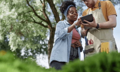 Polished Black woman reviews a tablet with a landscaping professional