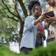 Polished Black woman reviews a tablet with a landscaping professional
