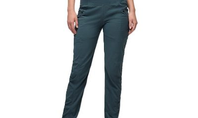 A woman wearing black sneakers, blue pants, and a gray cropped top