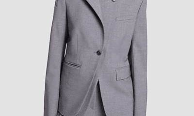 woman wears unusual blazer with two lapels, one buttons high on your neck and the other is a regular blazer lapel