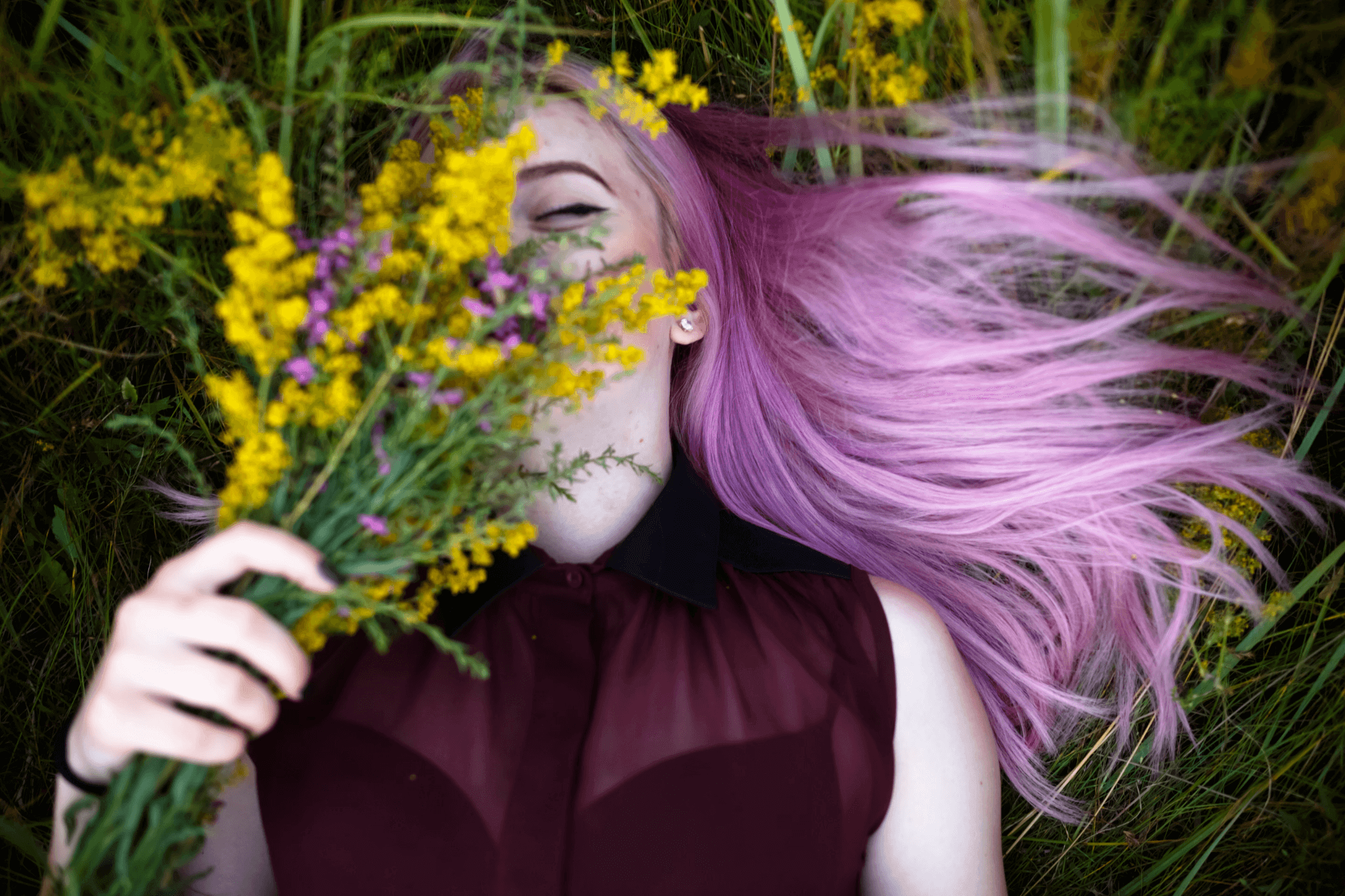 Woman with pink hair dye lying in a