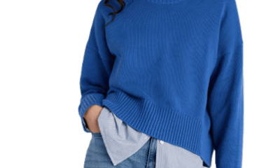 woman wears sapphire sweater with blue jeans; there is a blue collared button-front layered beneath the sapphire sweater