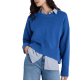 woman wears sapphire sweater with blue jeans; there is a blue collared button-front layered beneath the sapphire sweater