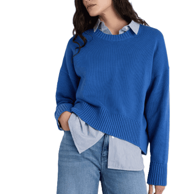 woman wears sapphire sweater with blue jeans; there is a blue collared button-front layered beneath the sapphire sweater