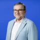 smiling portrait of a middle aged white man in a suit jacket