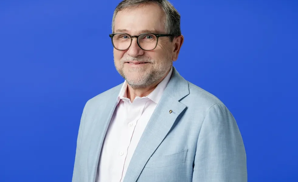 smiling portrait of a middle aged white man in a suit jacket