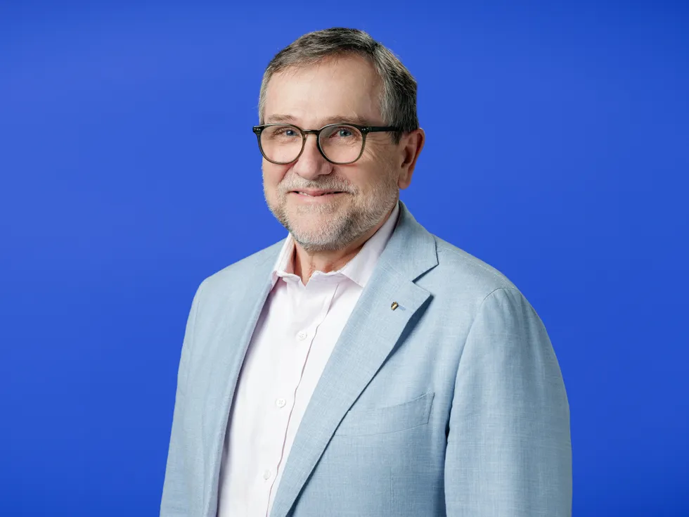 smiling portrait of a middle aged white man in a suit jacket